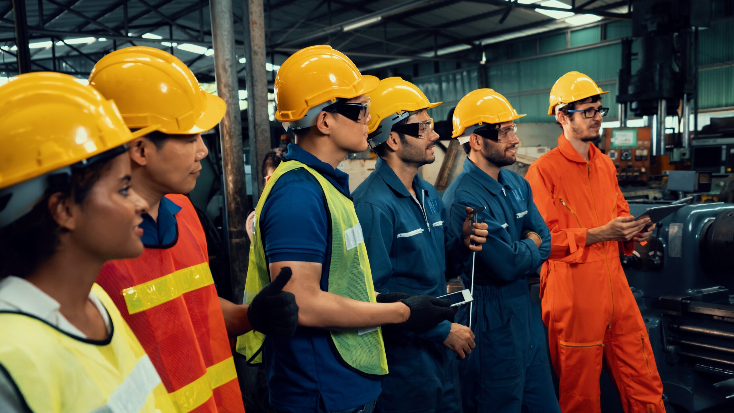 Skillful worker attending brief meeting in the factory . Industrial people and manufacturing labor concept .
