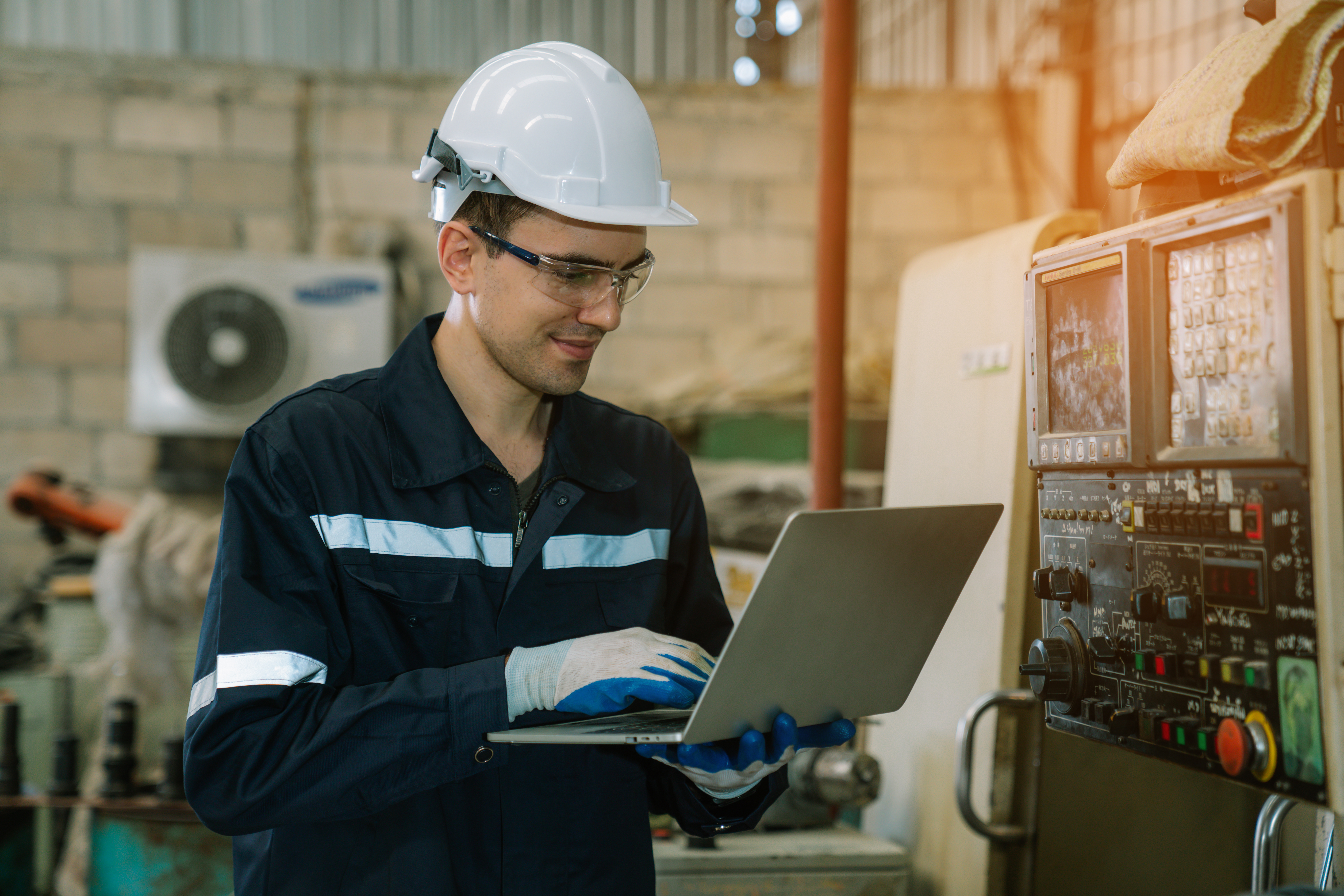 Engineers using laptop checking and repair pressing metal machin